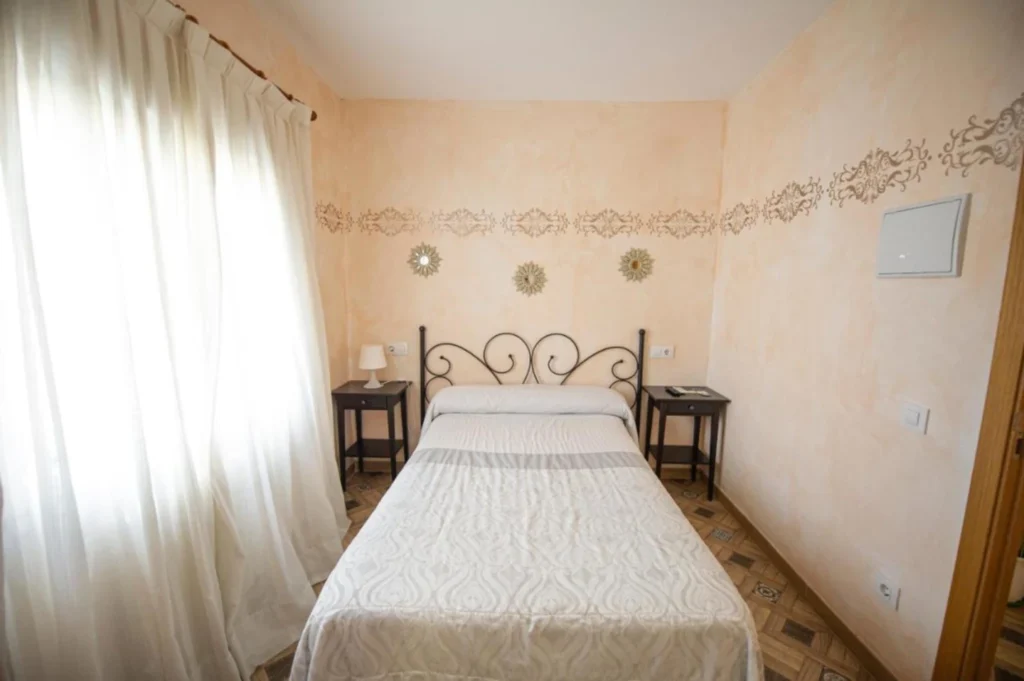 Habitación doble luminosa del Hostal Paquita en Madrid con decoración clásica y cama amplia