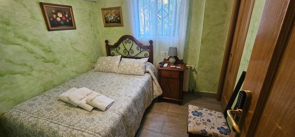 Habitación doble del Hostal Paquita en Madrid con cama matrimonial y decoración clásica